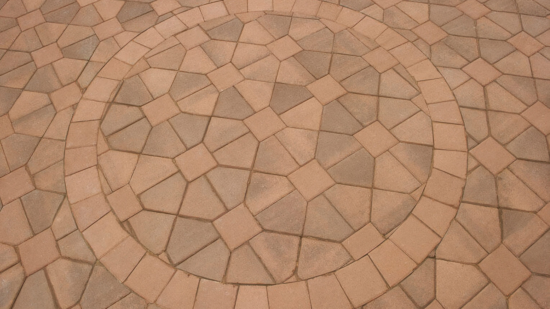 special ordered blended cream brown bishops hat paving stones and solid cream 8 by 8 paving stones installed in a venetian parquet pattern. circle is 8 by 8 solid cream field cut to create angles sides where necessary.