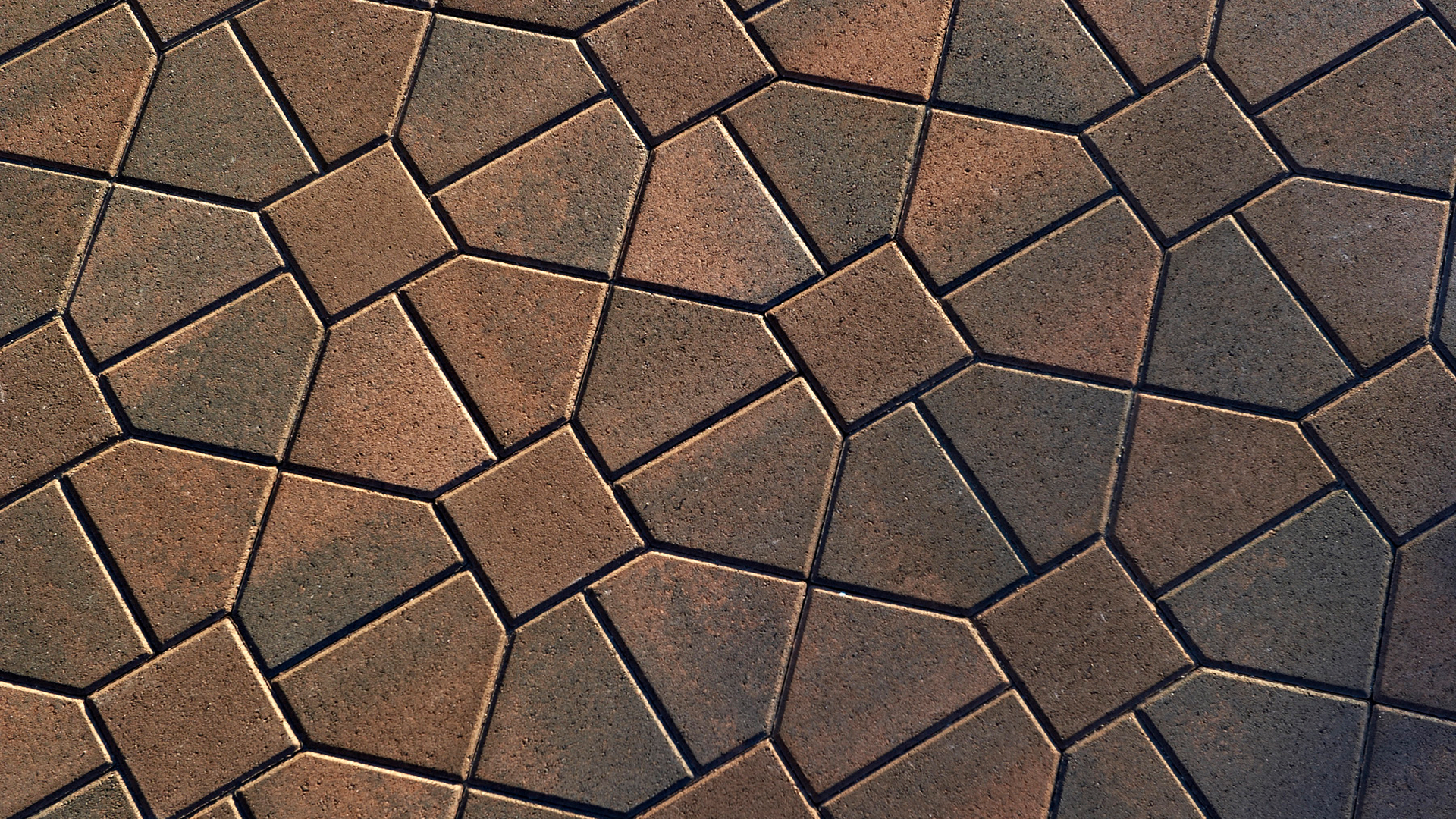 Close-up view of Cream-Brown-Charcoal Bishops Hat and Brown 8x8 pavers arranged in a Venetian Parquet pattern. The geometric layout features interlocking angular shapes and squares, creating a visually intricate and textured surface with rich earthy tones.