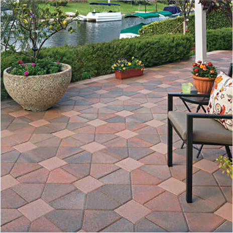 patio over looking waterway covered in blended cream terracotta brown bishops hat paving stones with solid cream 8 by 8 paving stones in the center. installed in a venetian parquet pattern.