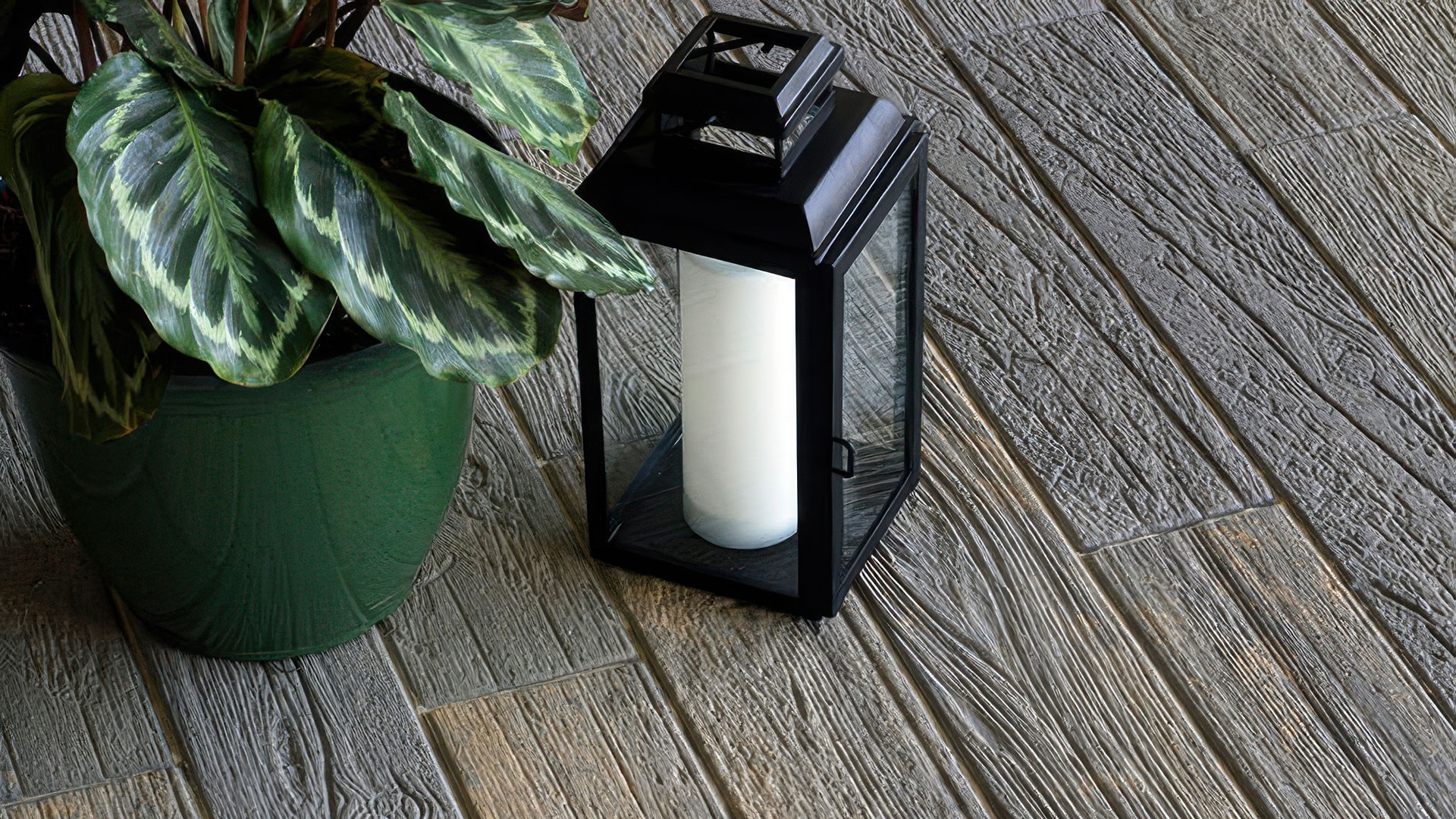 a patio with plant and lamp on it with blended dark gray copper charcoal timberline paving stones.