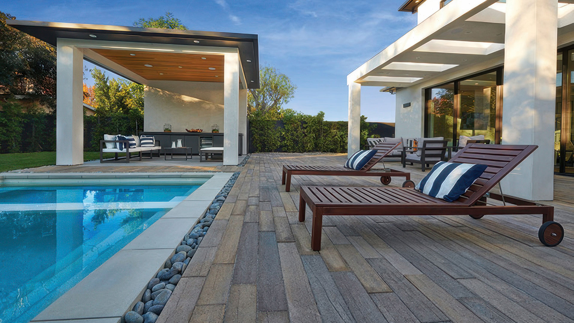 an amazing backyard patio and pool deck with outdoor pool and entertainment area. Patio and pool deck are covered in blended stone adobe mocha timberline paving stones.