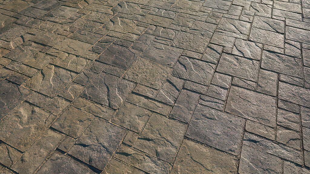Close-up of paving surface featuring Heartland pavers in Gray–Moss–Charcoal blend, installed in a random ashlar pattern. Textured surface highlights natural stone-like detail and color variation.