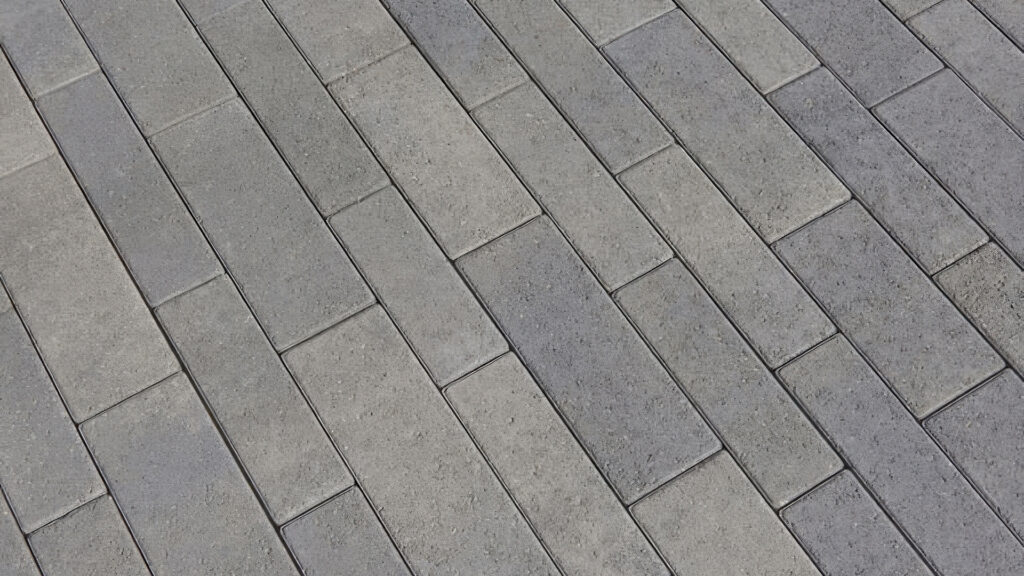 Close-up view of Dark Gray-Pewter-Charcoal Aqualina pavers installed in a random runner pattern. The clean, linear layout showcases the modern blend of cool-toned rectangular pavers with subtle texture and color variation.