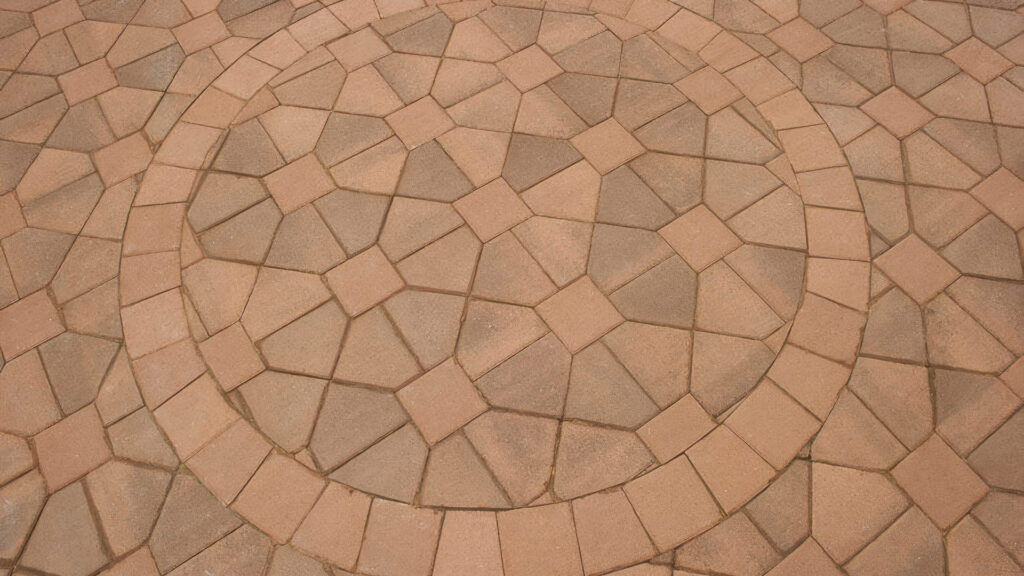 Close-up of a circular paving installation using Cream-Brown Bishops Hat and Cream 8x8 pavers in a Venetian Parquet pattern. The circle is crafted from precisely cut 8x8 pavers to form angled edges, harmonizing with the geometric diamond and square layout for a distinct decorative effect.
