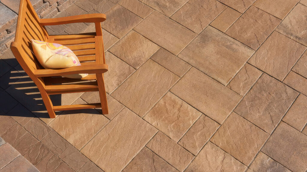 Pavilion I and II pavers in Adobe-Copper-Mocha color, installed in a random ashlar pattern, with poolside seating and a covered outdoor kitchen.